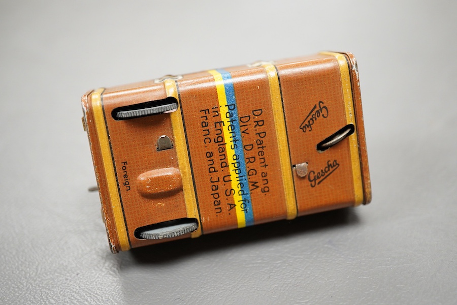 A Gescha, DRGM (Germany), clockwork tinplate acrobatic bellboy on ‘Express’ trunk, together with a Schuco, Germany tinplate and cellulose clockwork man with girl automaton